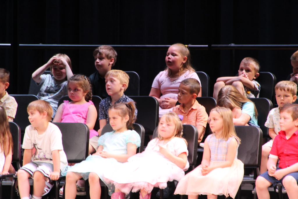 students seated on risers on stage