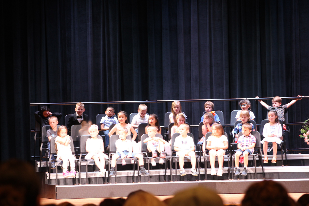 students seated on risers on stage