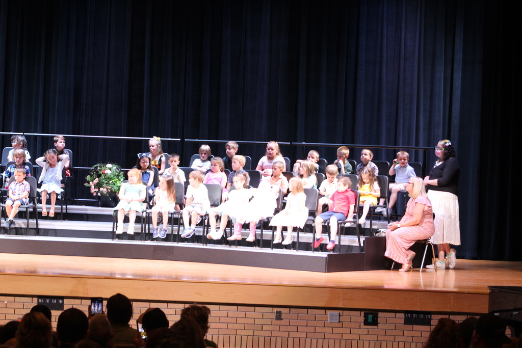 students seated on risers on stage