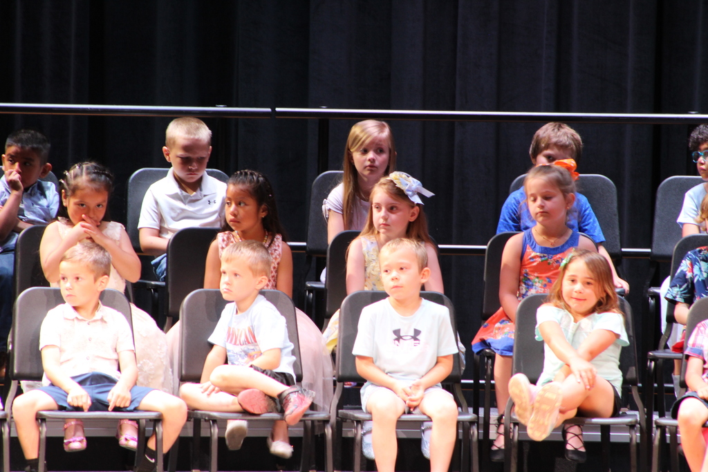 students seated on risers on stage