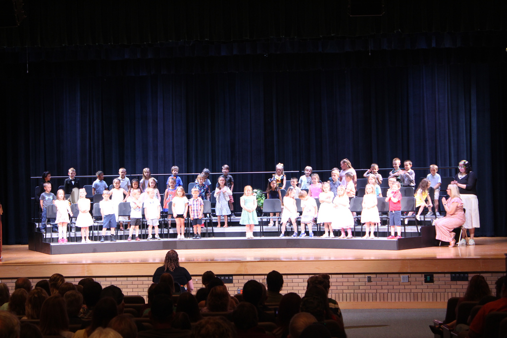 students standing on risers on stage