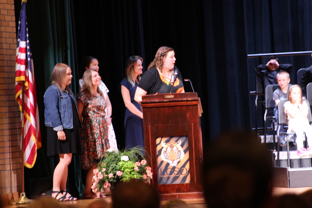 teachers standing by lectern on stage