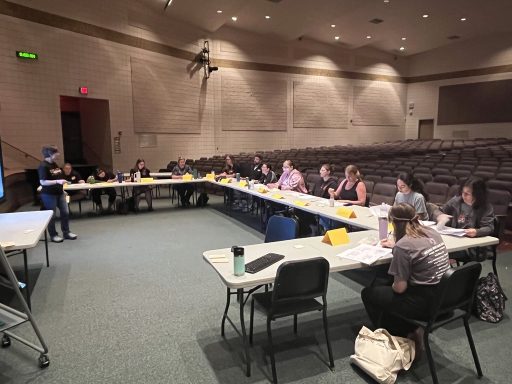 staff sitting around tables in auditorium