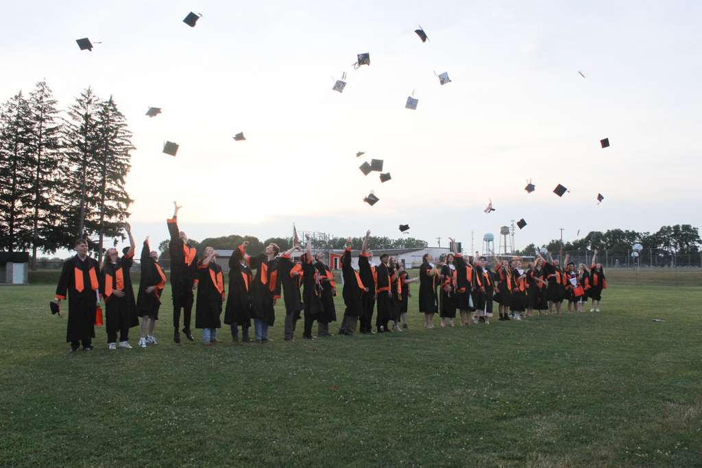 graduating seniors throwing their caps in the air