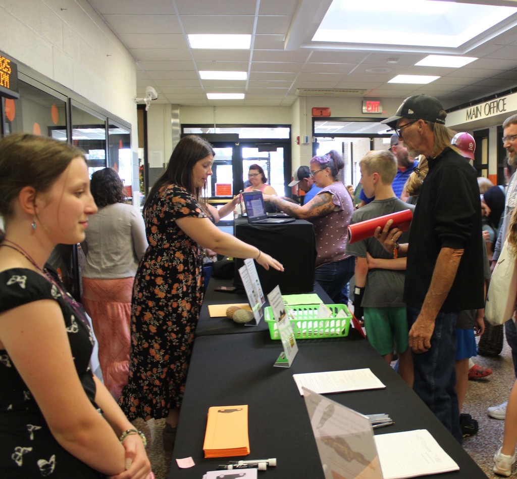 people standing around tables receiving information
