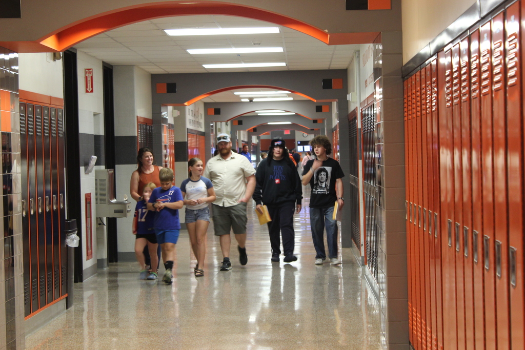 people walking down hallway