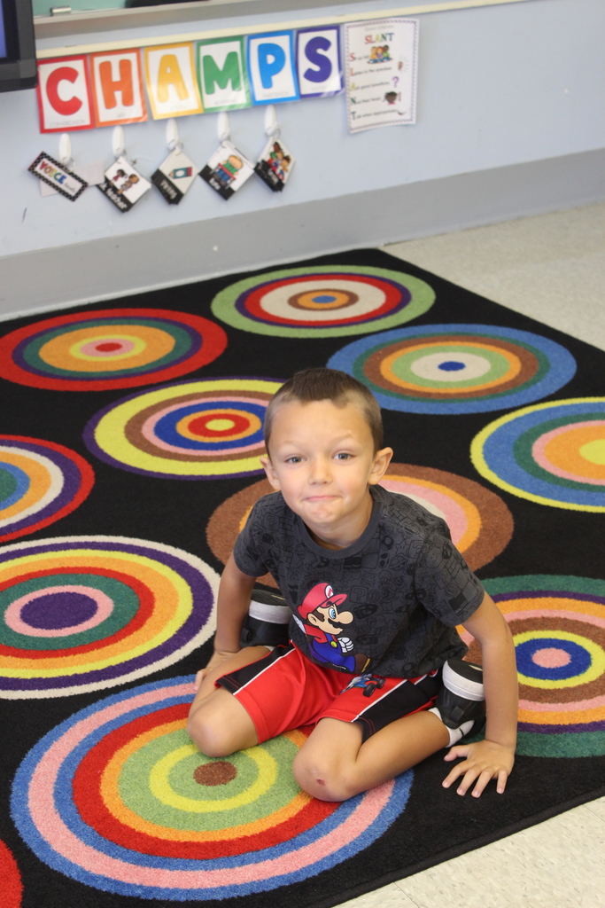 boy sitting on patterned carpet