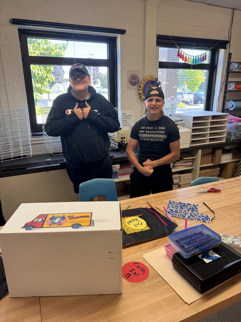 two boys standing behind a table in art class
