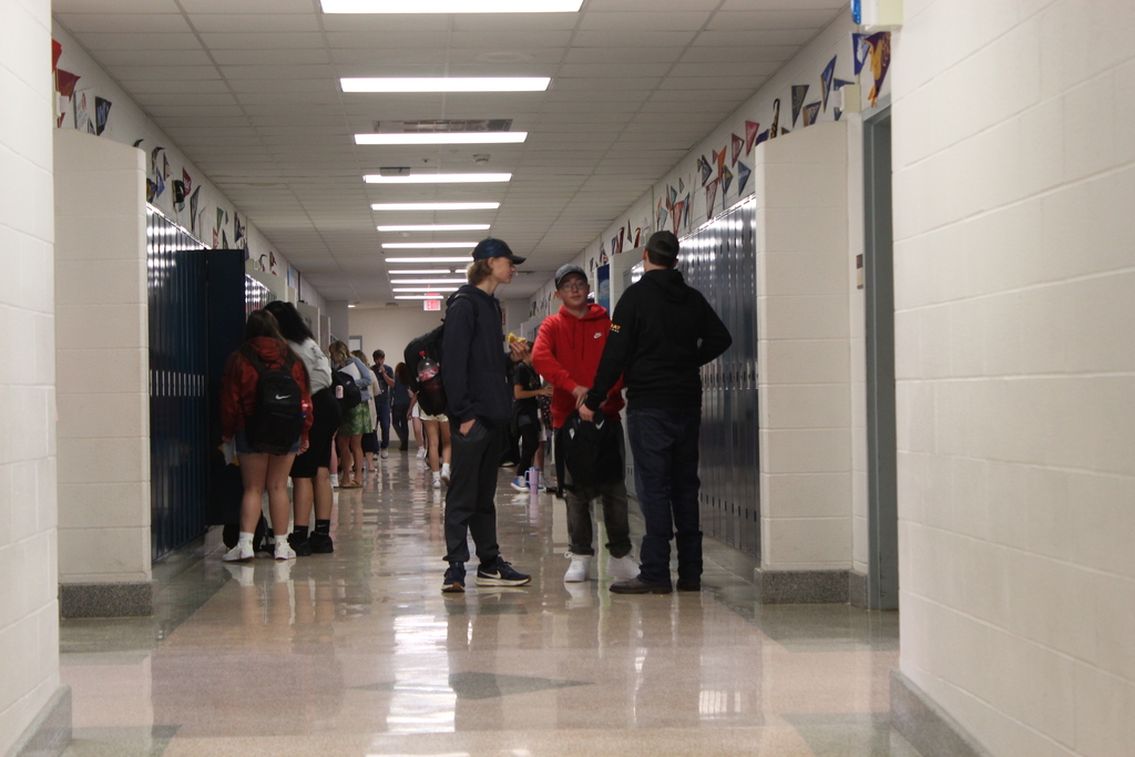 students standing near lockers in hallway
