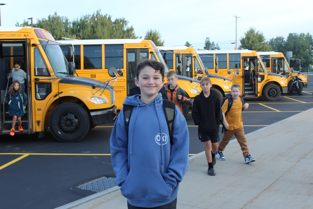 student walking down sidewalk with other students behind him