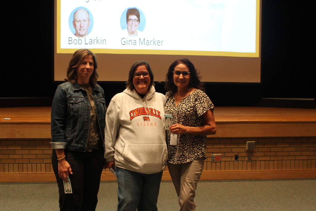 three teachers holding pins