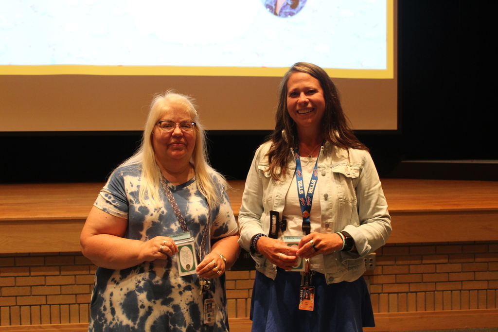 two staff members holding pins