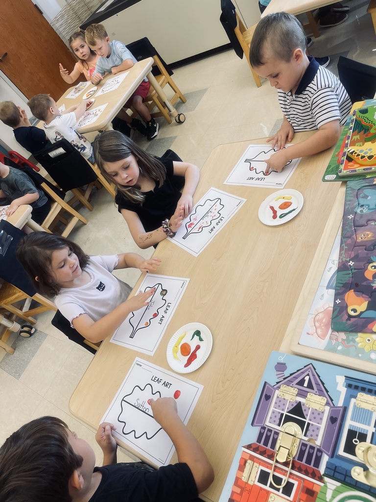 students sitting at tables painting 