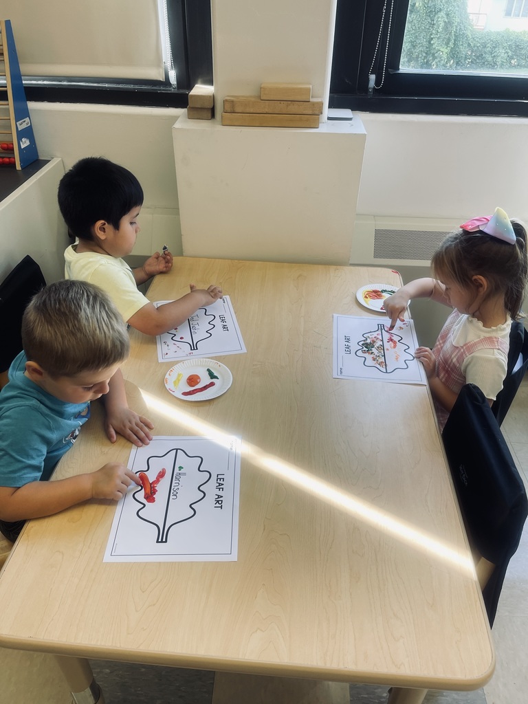 students sitting at table painting 