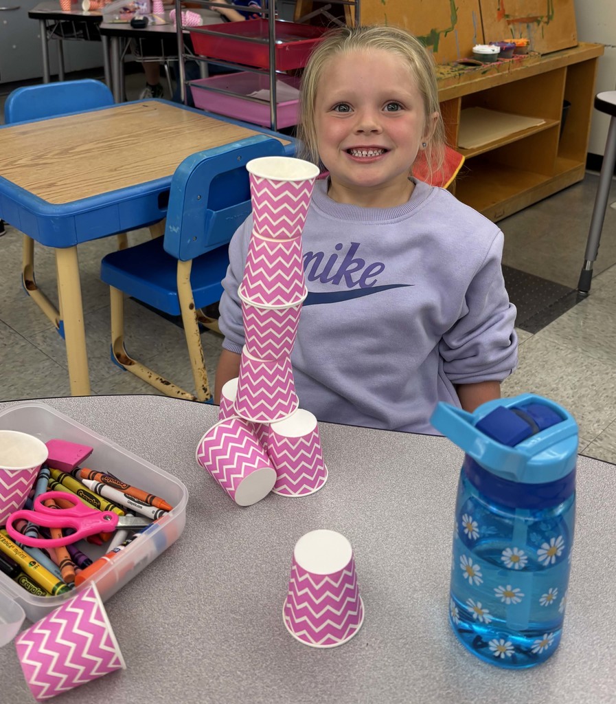 girl stacking cups on table