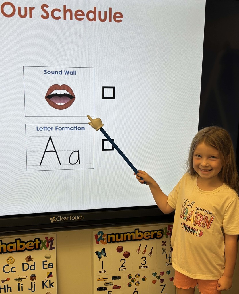 girl pointing at something on the smartboard