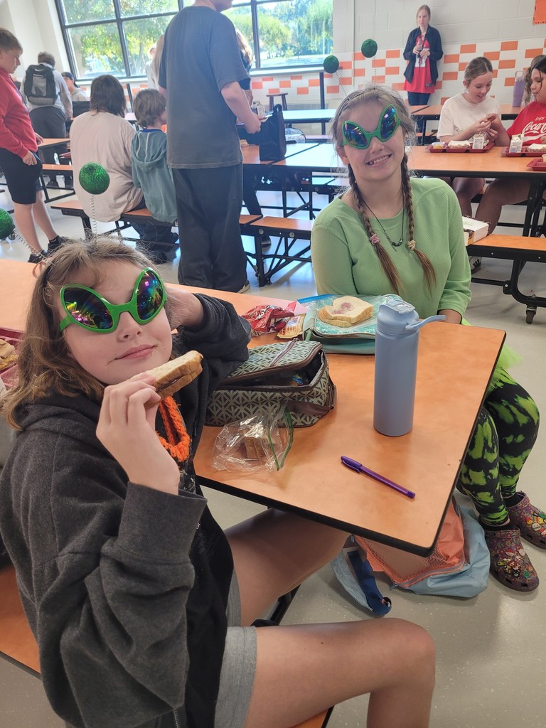 two students wearing matching headbands and sunglasses in the lunchroom