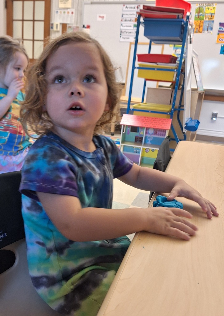 student sitting at table wearing tie-dye outfit