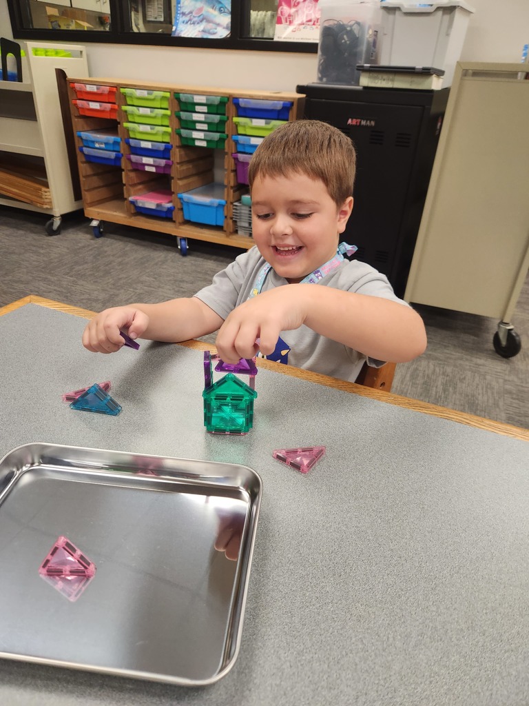 boy sitting at table manipulating toys
