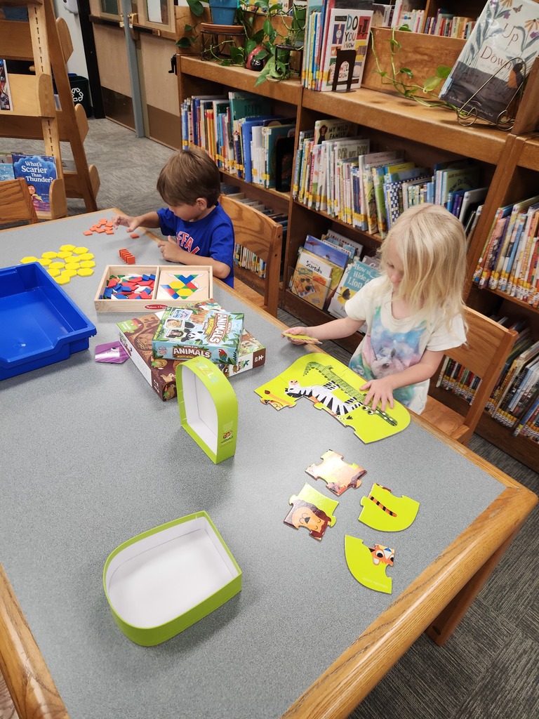 two students working on puzzles at table