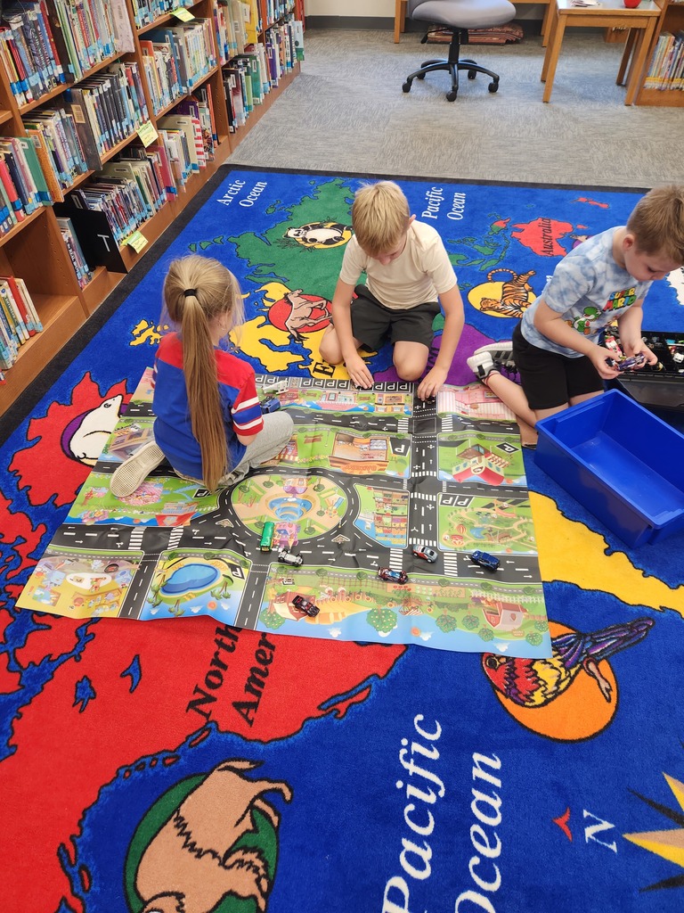 three students playing on the floor