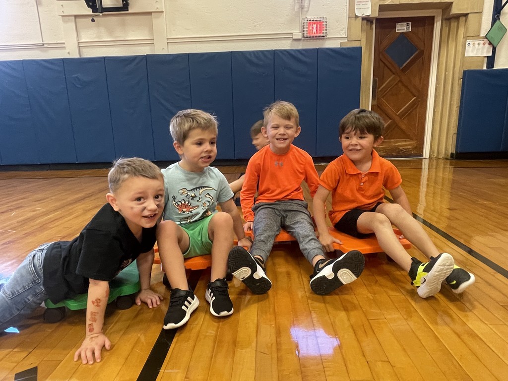 boys sitting on scooters in gym