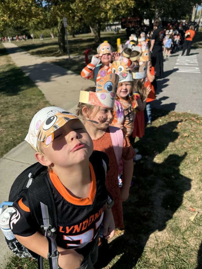 students standing on sidewalk waiting for parade