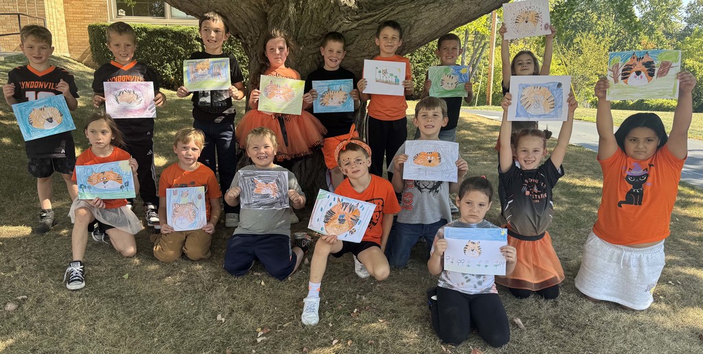 students holding their drawings of tigers