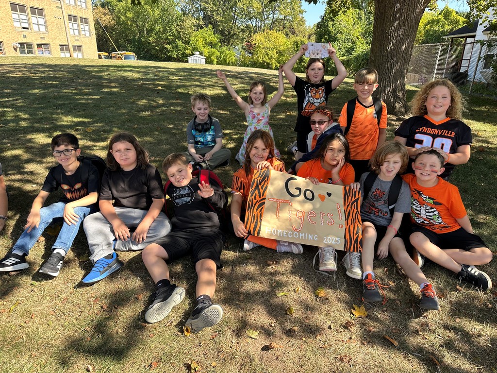 a group of students on the lawn holding signs