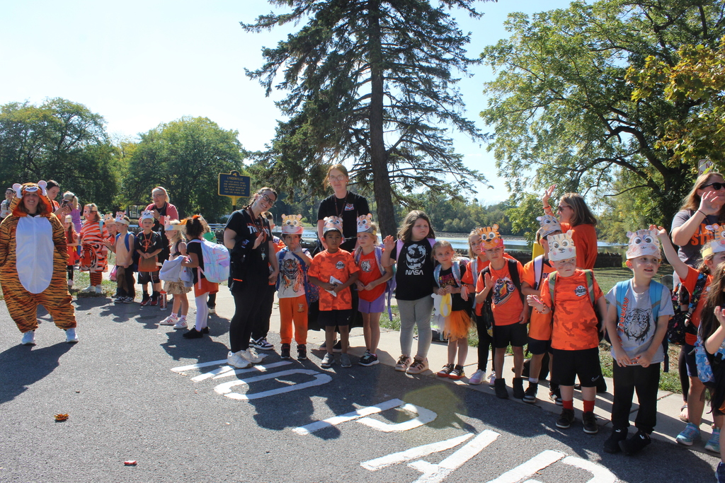 students on the sidewalk with teachers waiting for the parade