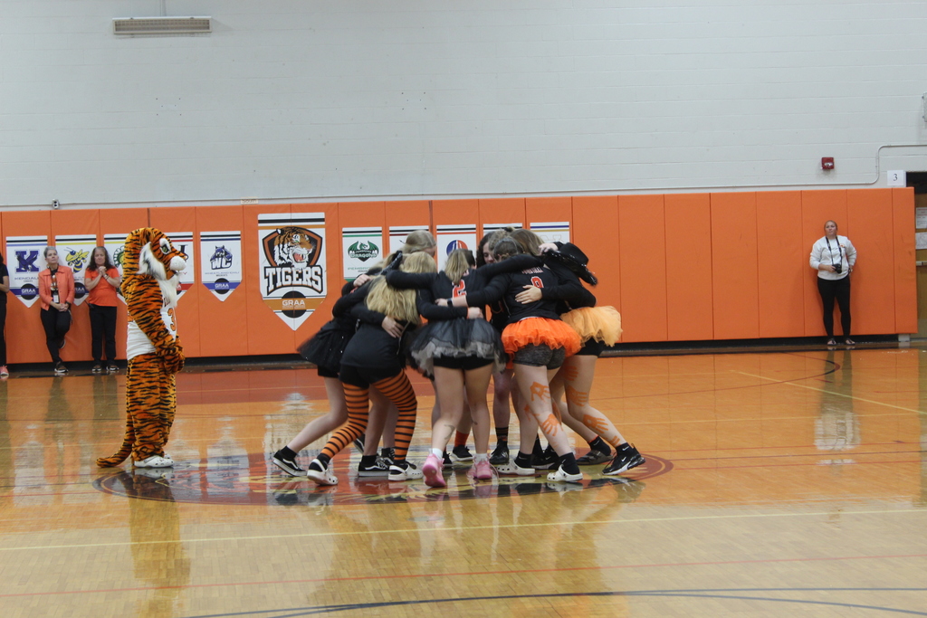 team gathered in a circle in the gym