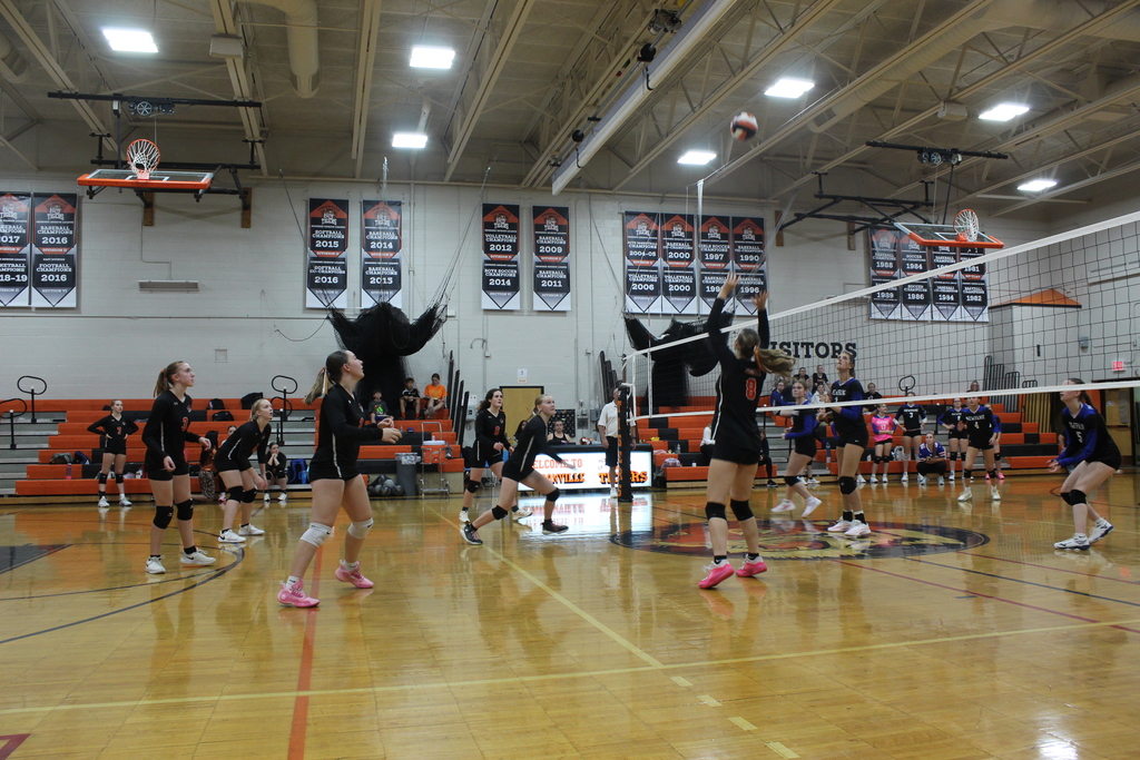 girls playing volleyball in gym