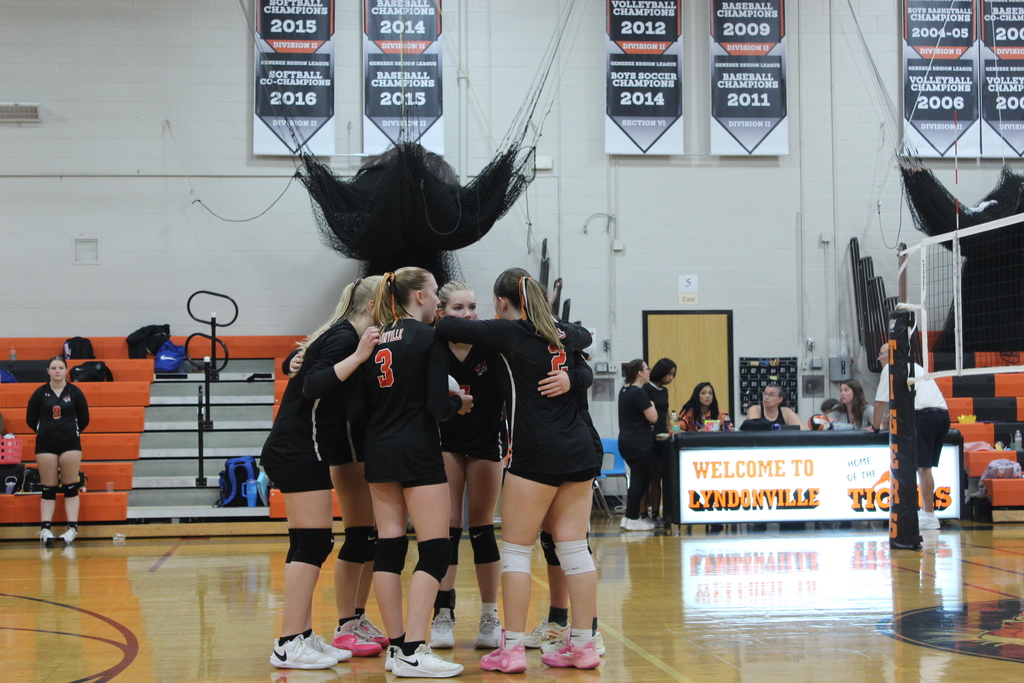 girls huddling together during volleyball game