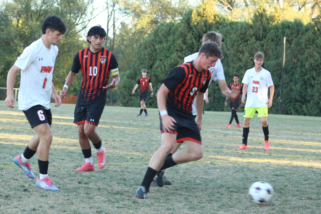 boys playing soccer on field