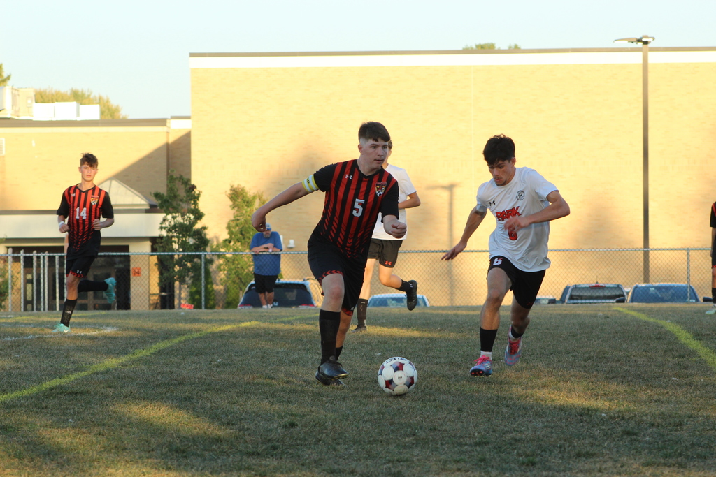 boys playing soccer on field