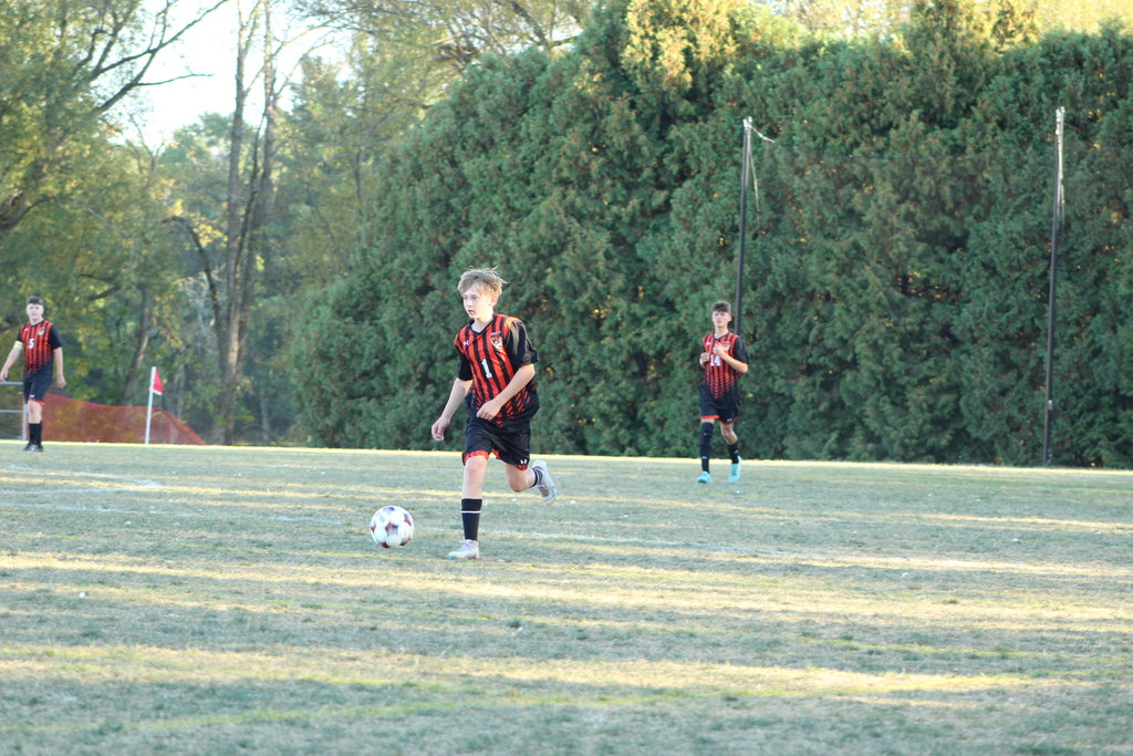 boys playing soccer on field