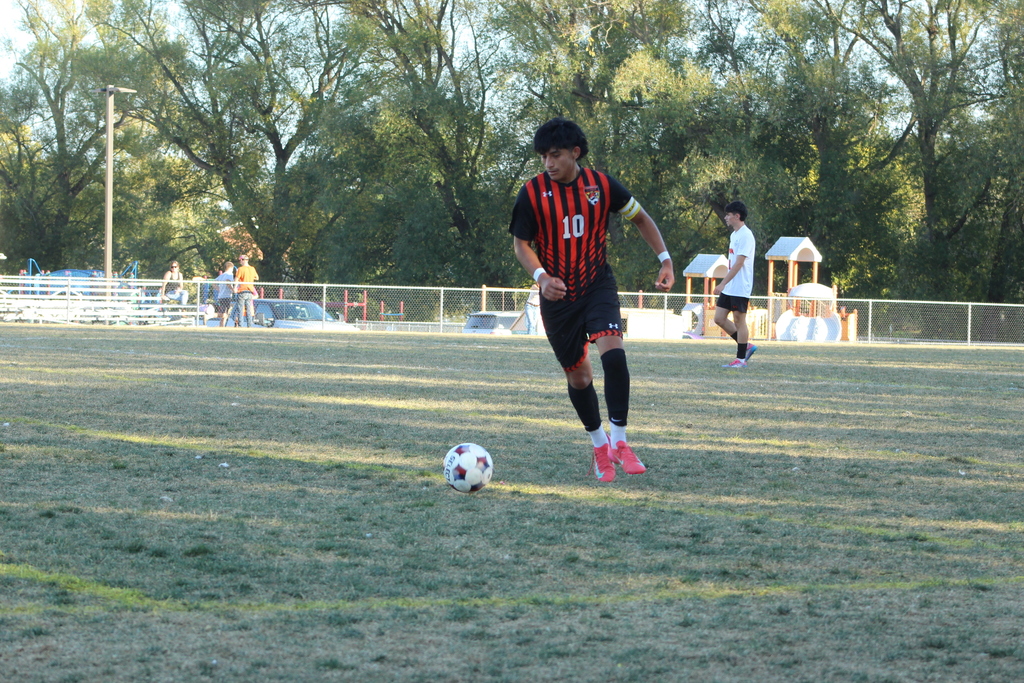 boys playing soccer on field
