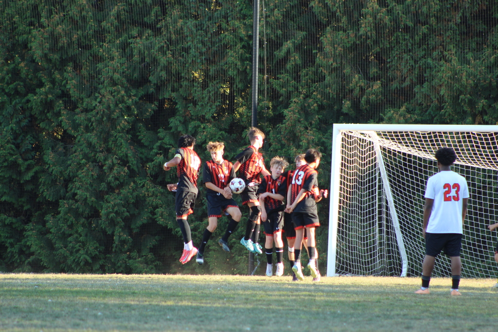 boys playing soccer on field