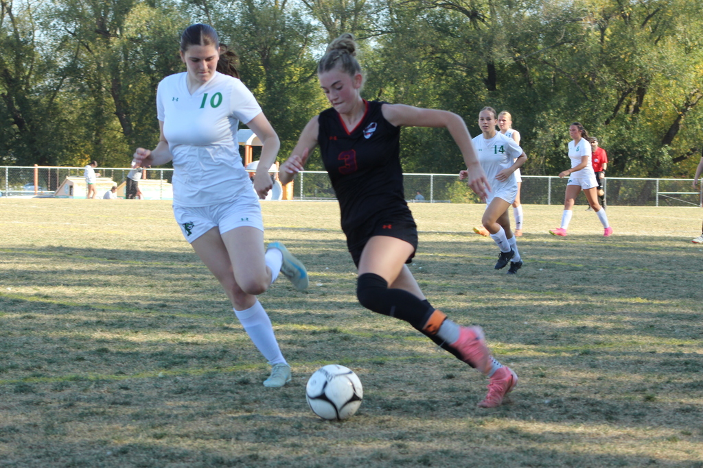 girls playing soccer on the field