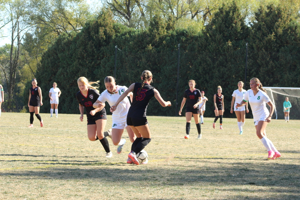 girls playing soccer on the field