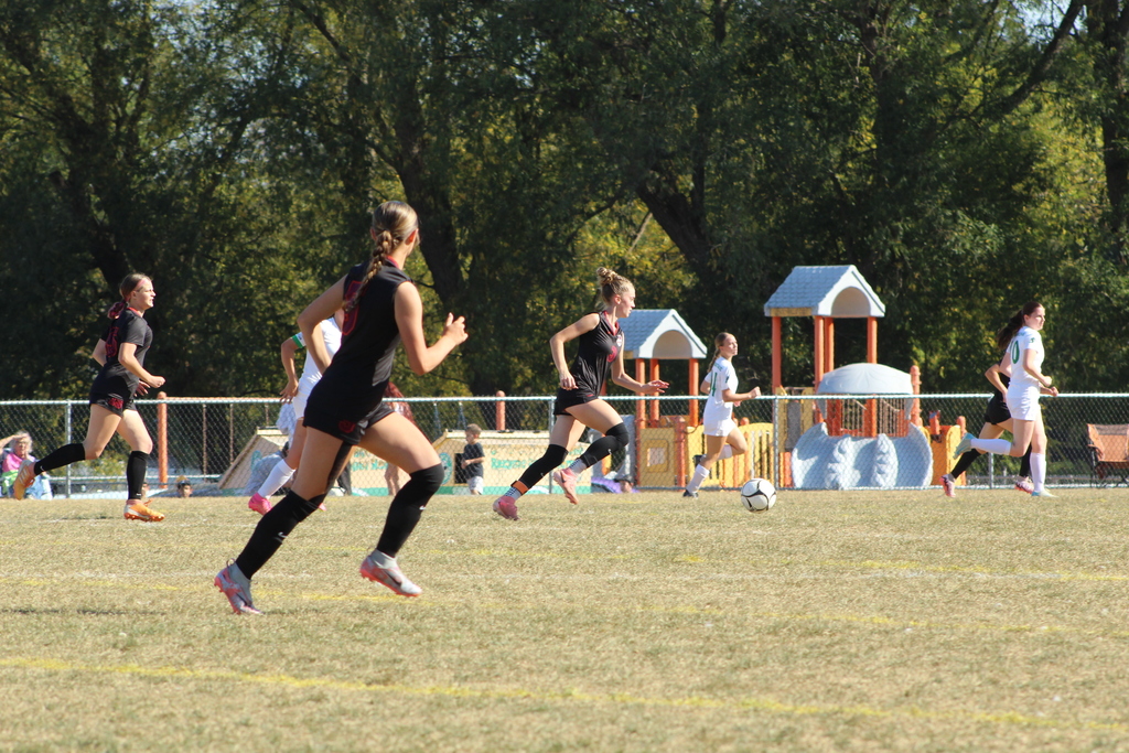 girls playing soccer on the field