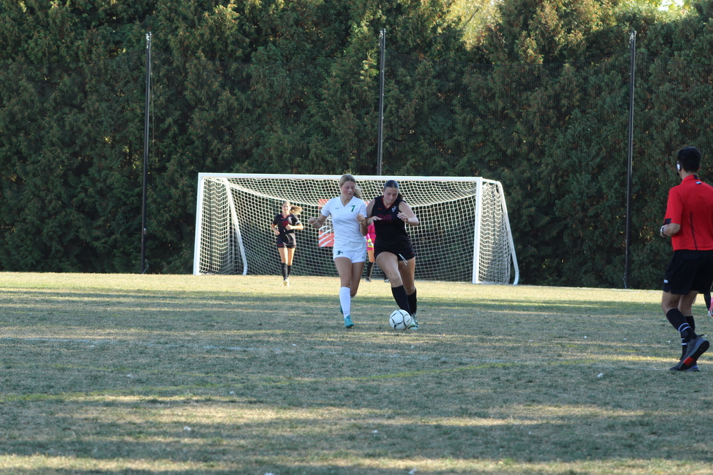 girls playing soccer on the field