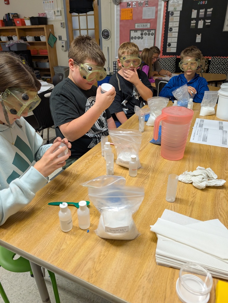 students seated at table doing science experiments