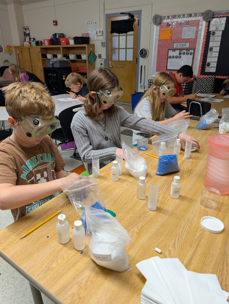 students seated at table doing science experiments