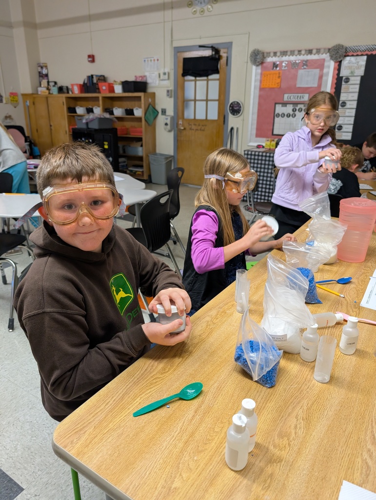 students seated at table doing science experiments