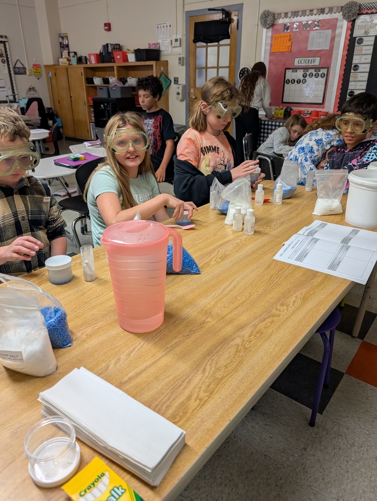 students seated at table doing science experiments