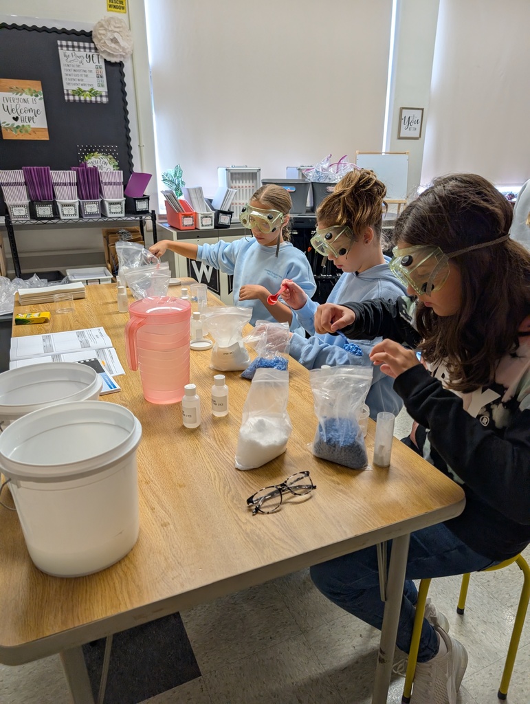 students seated at table doing science experiments