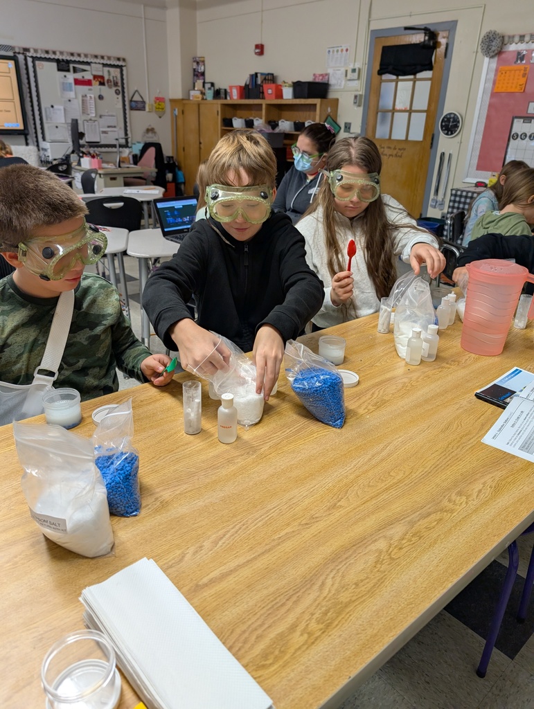 students seated at table doing science experiments