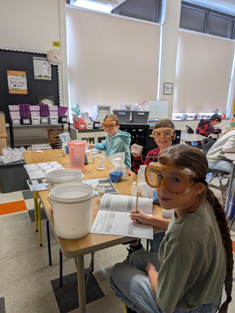 students seated at table doing science experiments