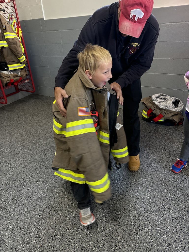student trying on fireman's jacket